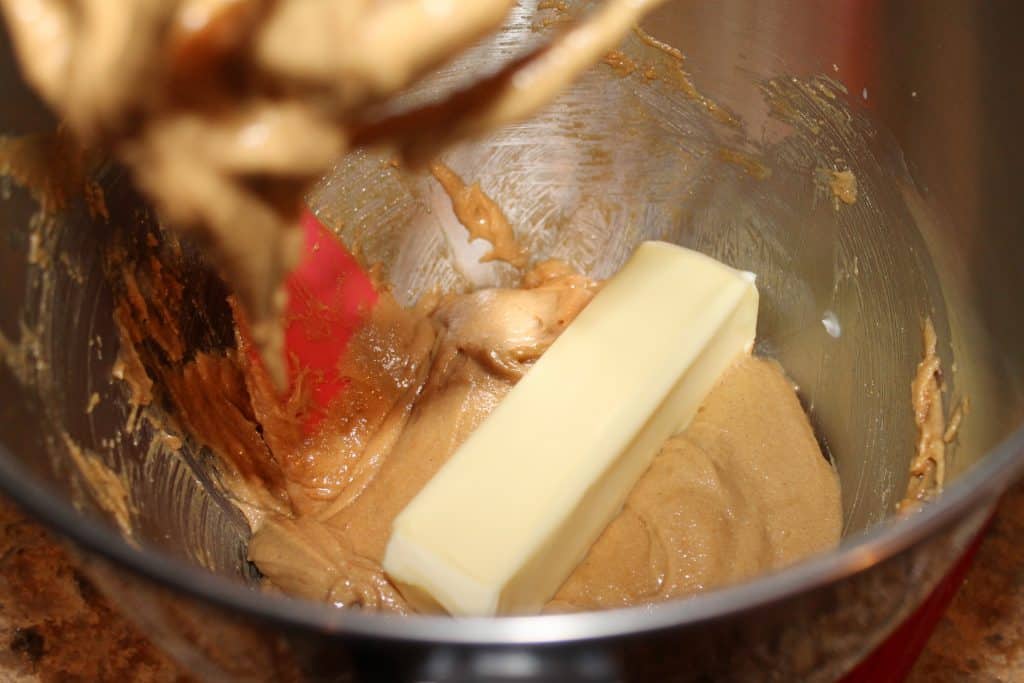 Adding the softened butter to the peanut butter cookie mixture.