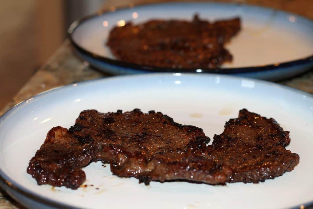 Pan seared steak resting on a plate before serving