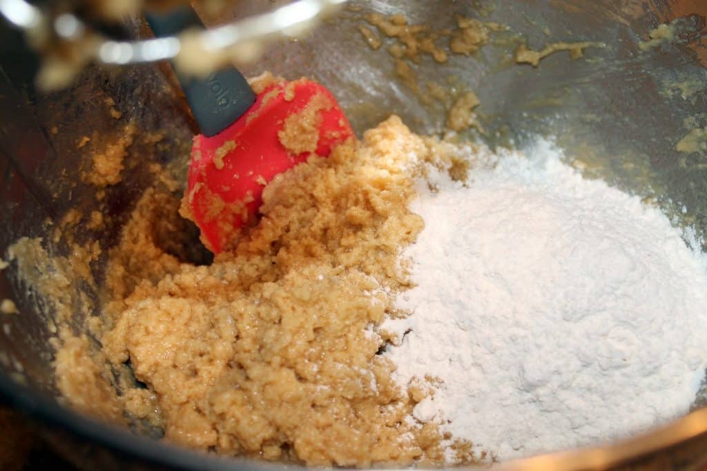 Adding flour to the mixing bowl.