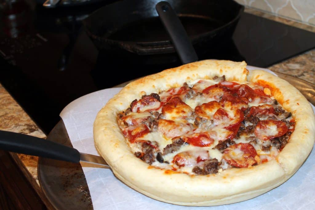 Skillet pizza lifter out of pan with 2 spatulas
