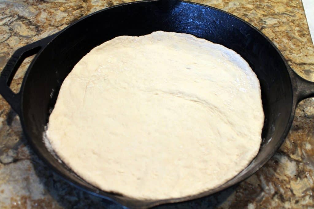 Pizza dough placed into cast iron skillet