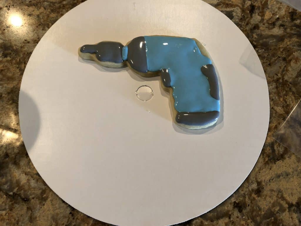 Adding the blue royal icing to the drill cookie