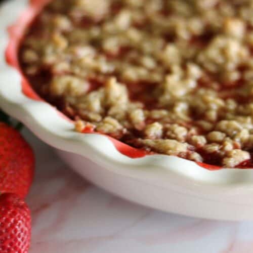 strawberry crisp with a few fresh strawberries beside it