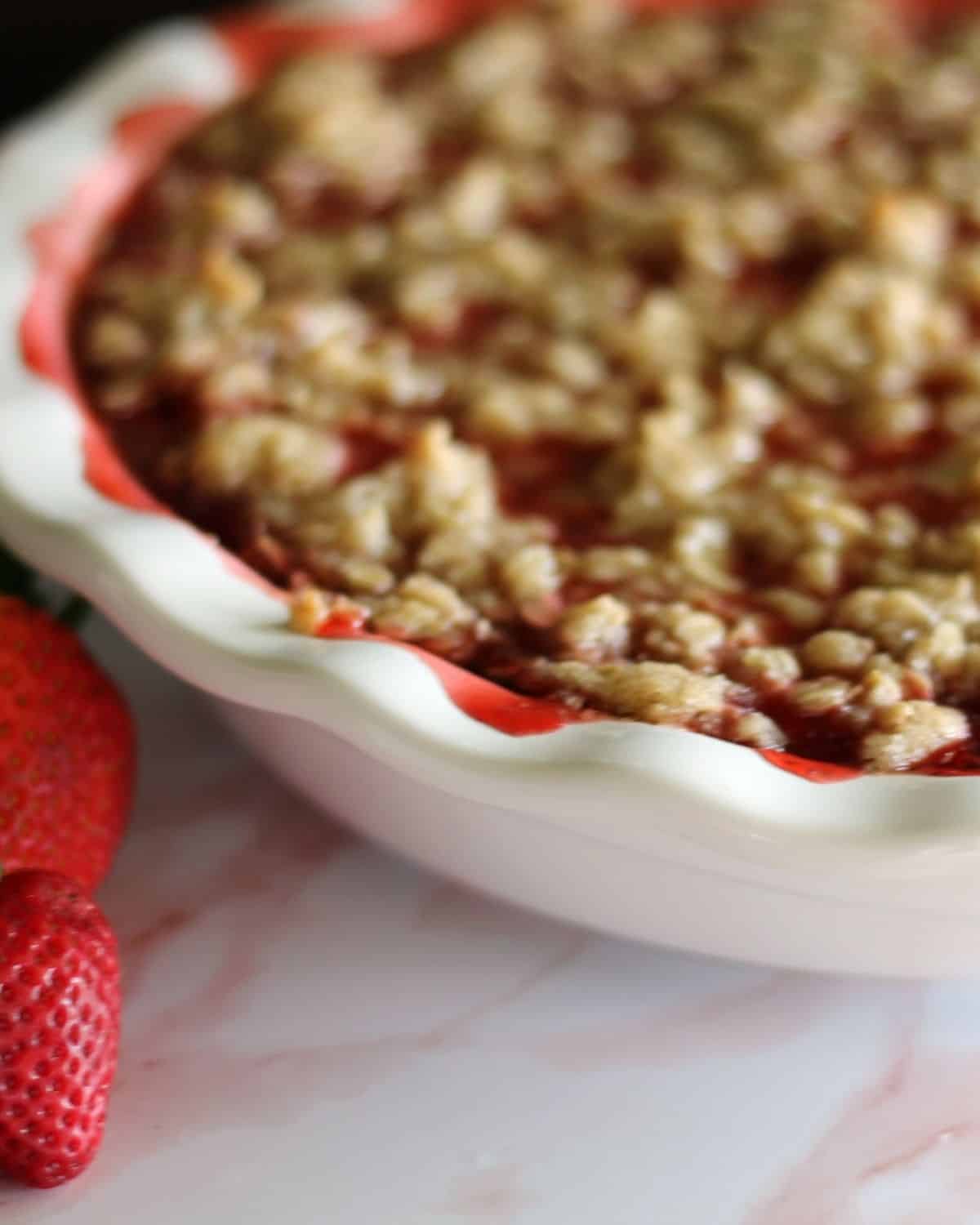 strawberry crisp with a few fresh strawberries beside it