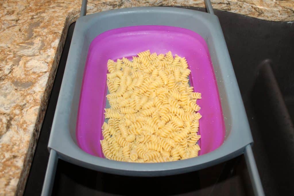 cooked pasta draining in a purple colander