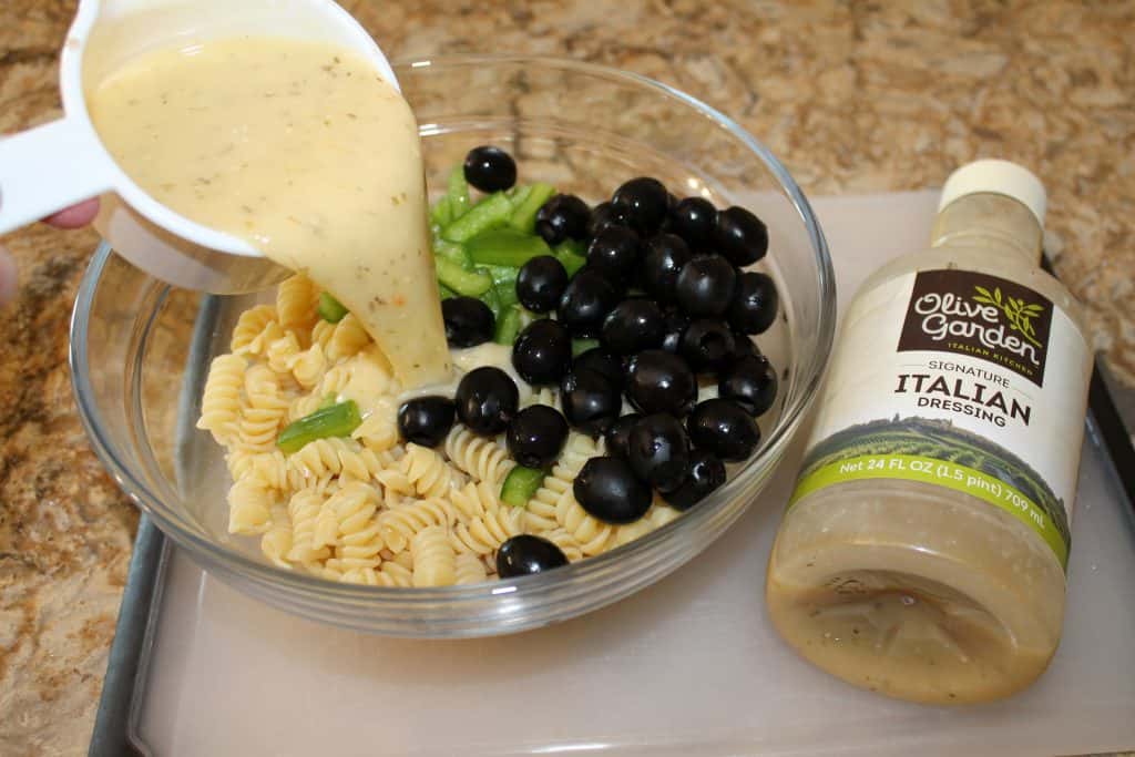 pasta salad being assembled in a large bowl