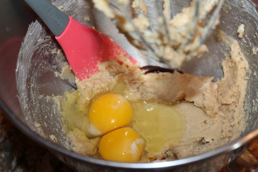 adding eggs and vanilla extract to the creamed butter mixture