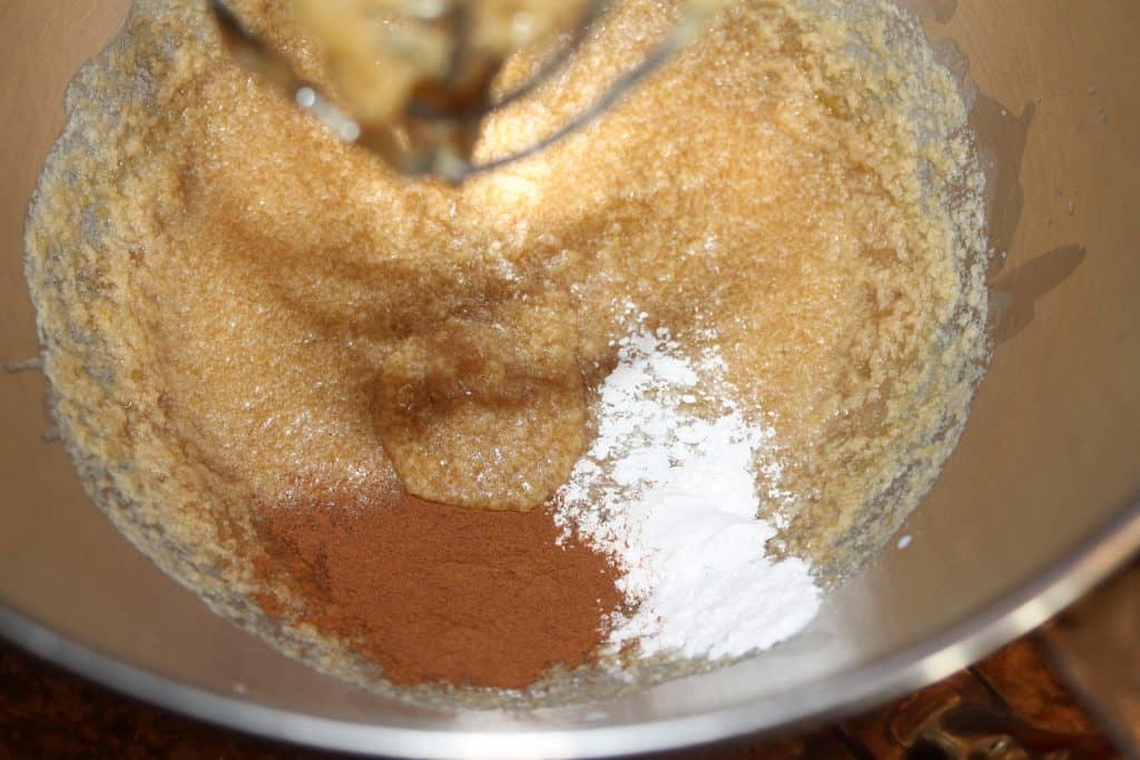 adding ground cinnamon and baking powder to the mixing bowl