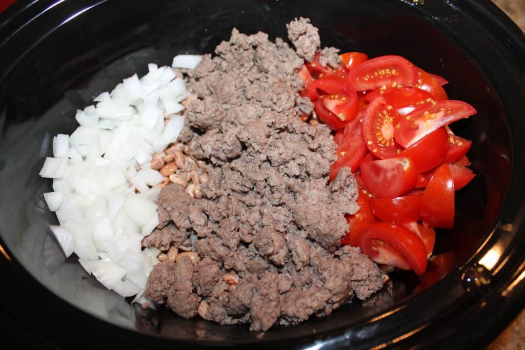 slow cooker with beans tomatoes cooked hamburer and onions