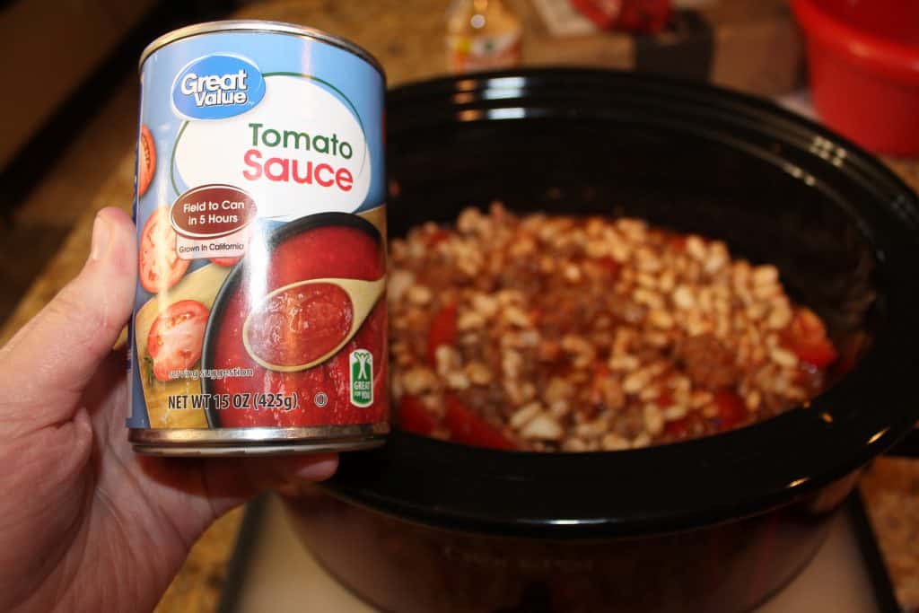 adding tomato sauce to crock pot