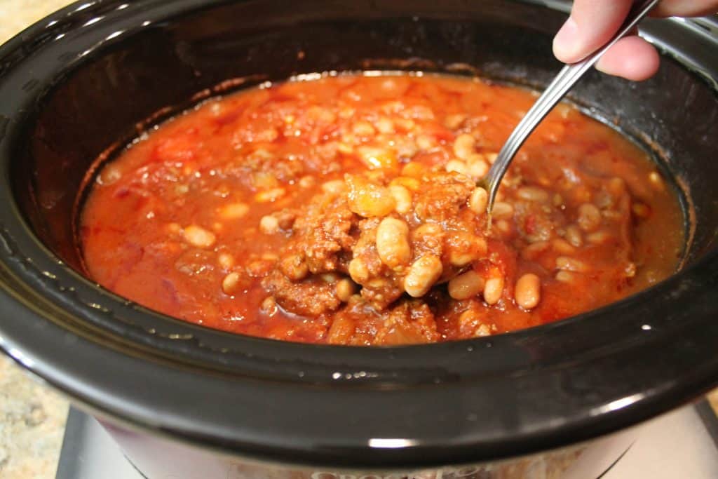 finished chili getting scooped out of a slow cooker