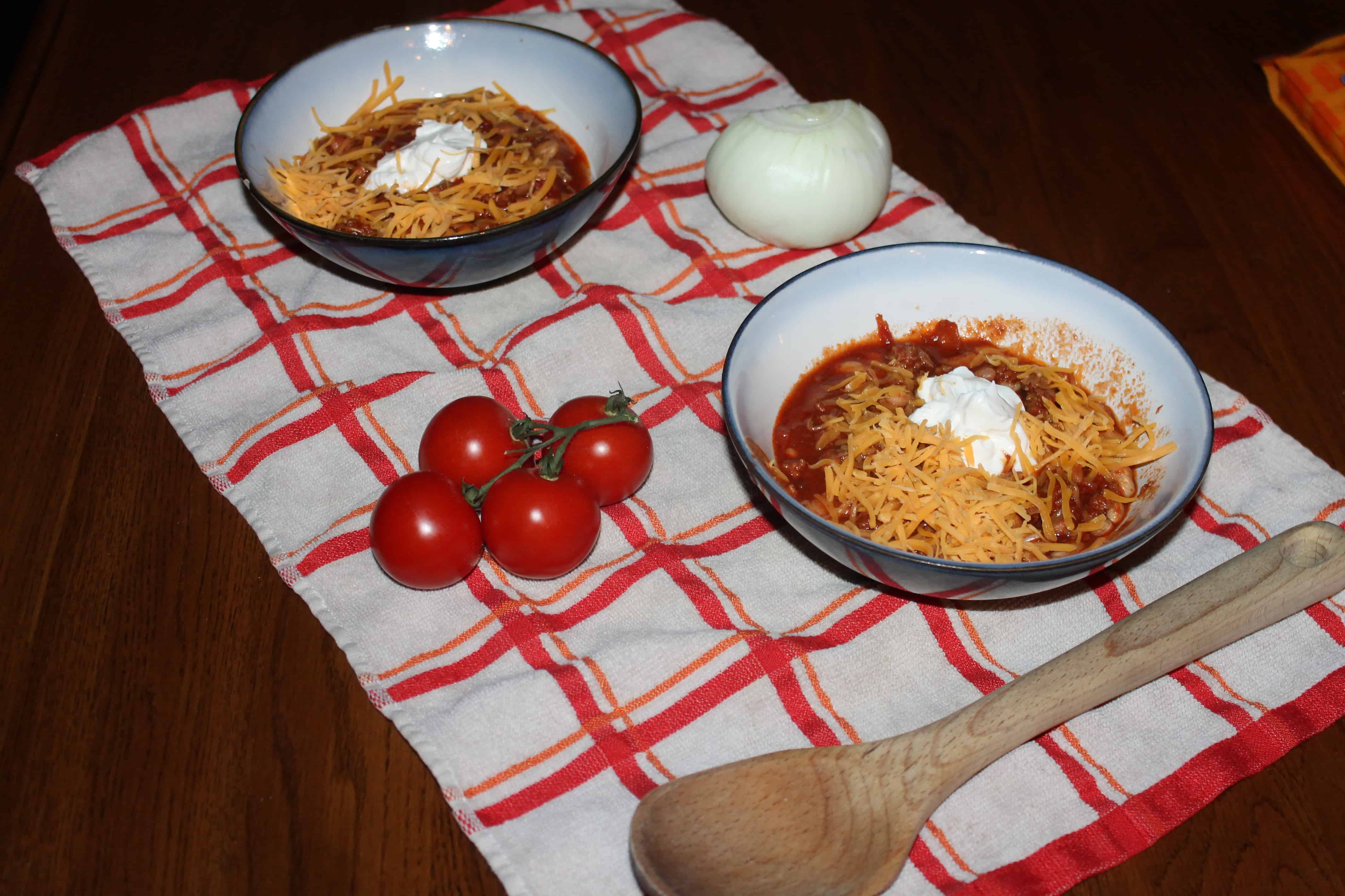 bowls of chili with cheese and sour cream ready to eat