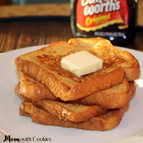 close up of four french toast stacked on top with butter and syrup