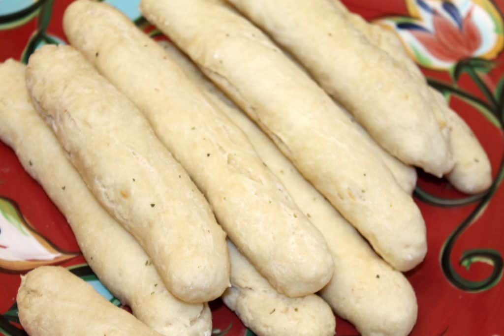 more garlic breadsticks on a large serving plate