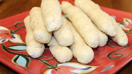 a red plate with garlic breadsticks