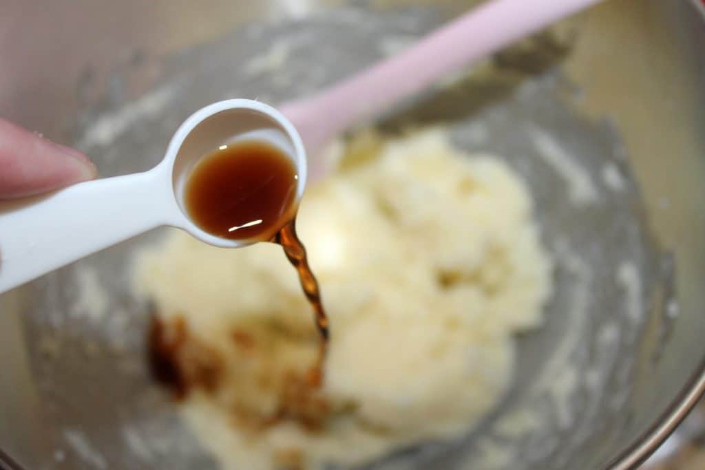 pouring the vanilla extract into the mixing bowl