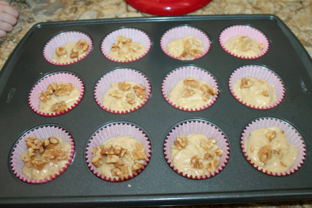 banana nut muffin batter scooped into the muffin pan