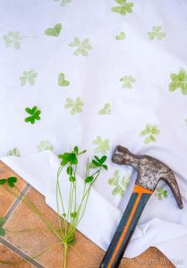 a white fabric with hammered clovers into the cloth to leave an imprint
