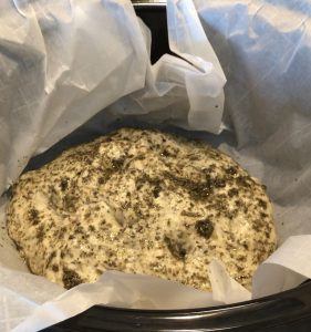 focaccia dough with olive oil and herbs brushed on top