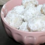 bowl of mexican wedding cookies topped with powdered sugar