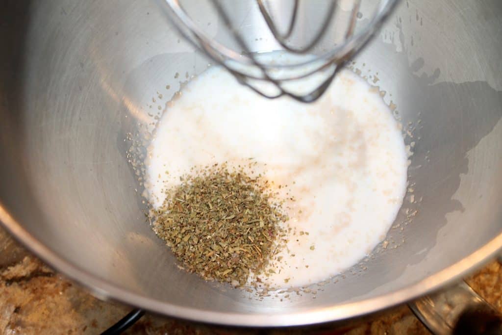 mixing bowl with Italian seasonings added to yeast mixture