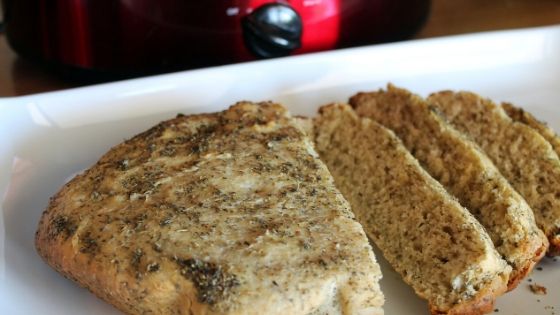 freshly baked focaccia bread sliced in front of a slow cooker