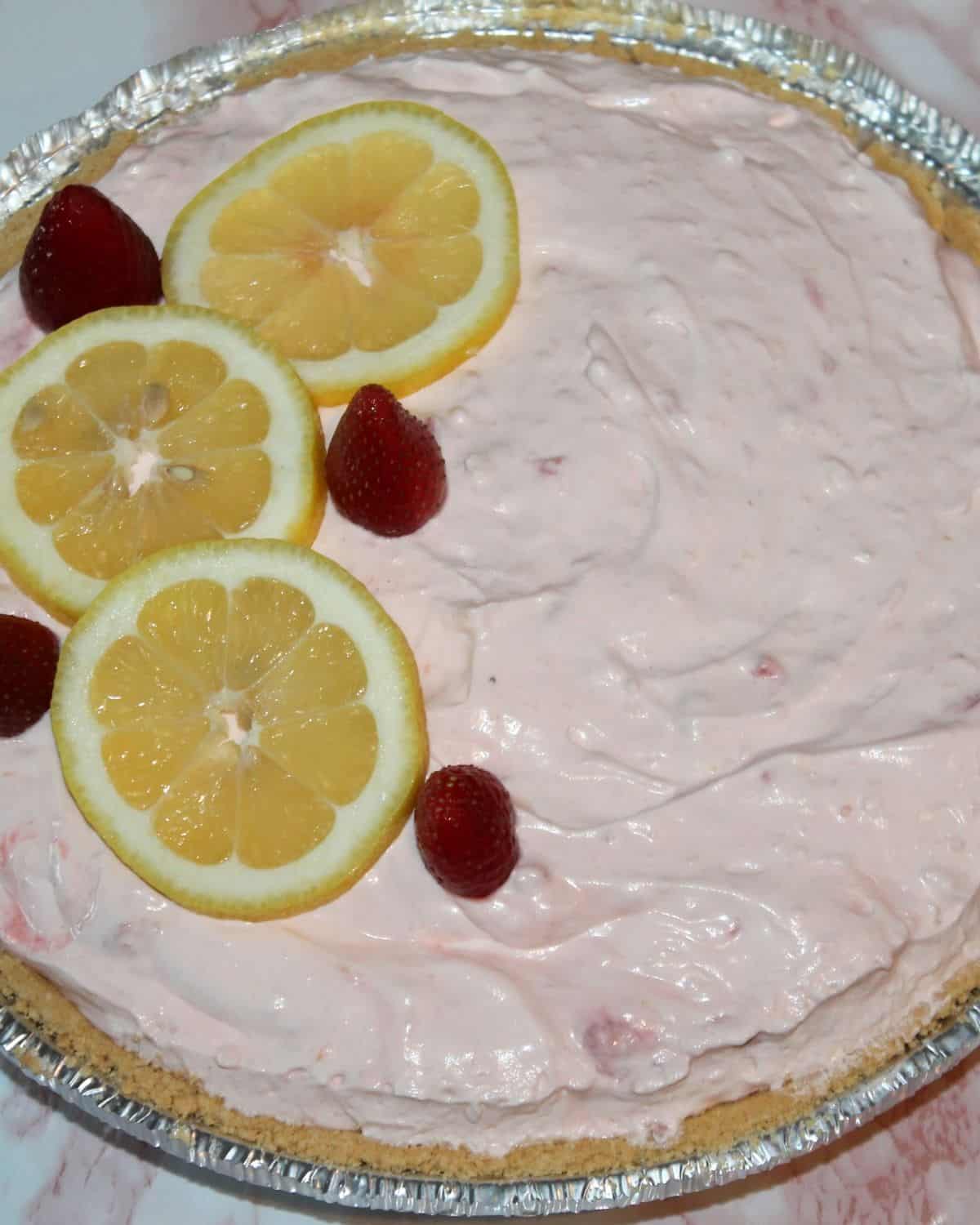 no bake strawberry lemon cream pie with lemon slices and strawberries on top