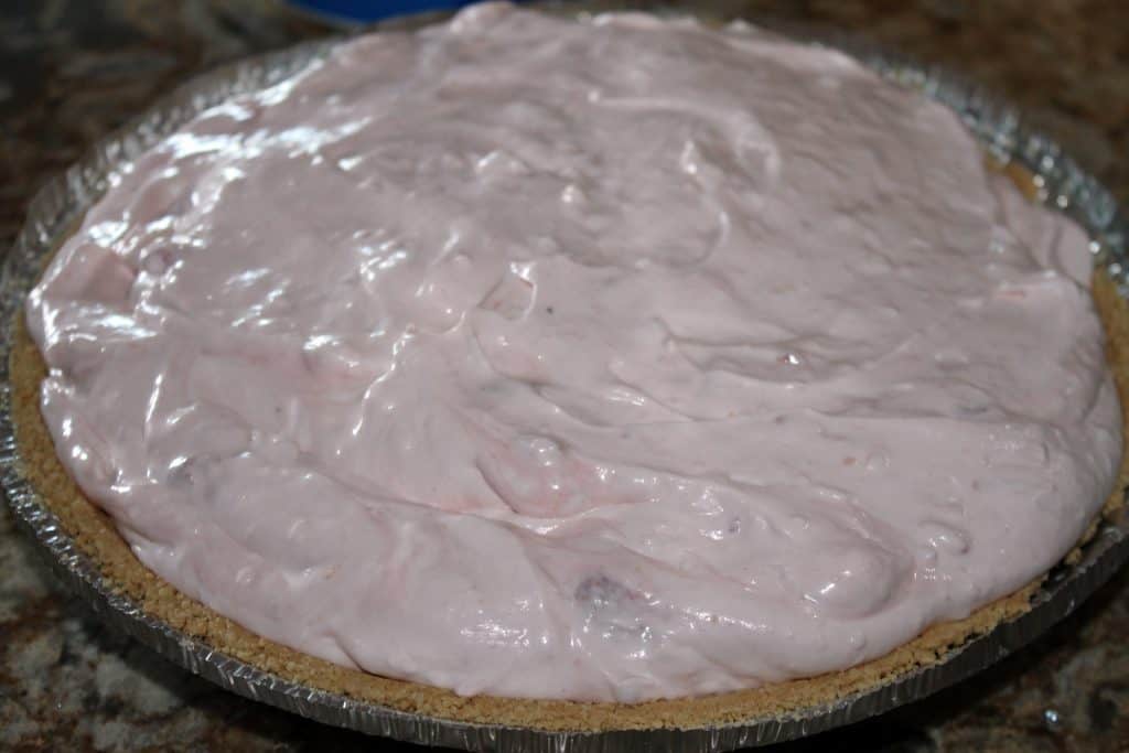 pie filling scooped into graham cracker crust