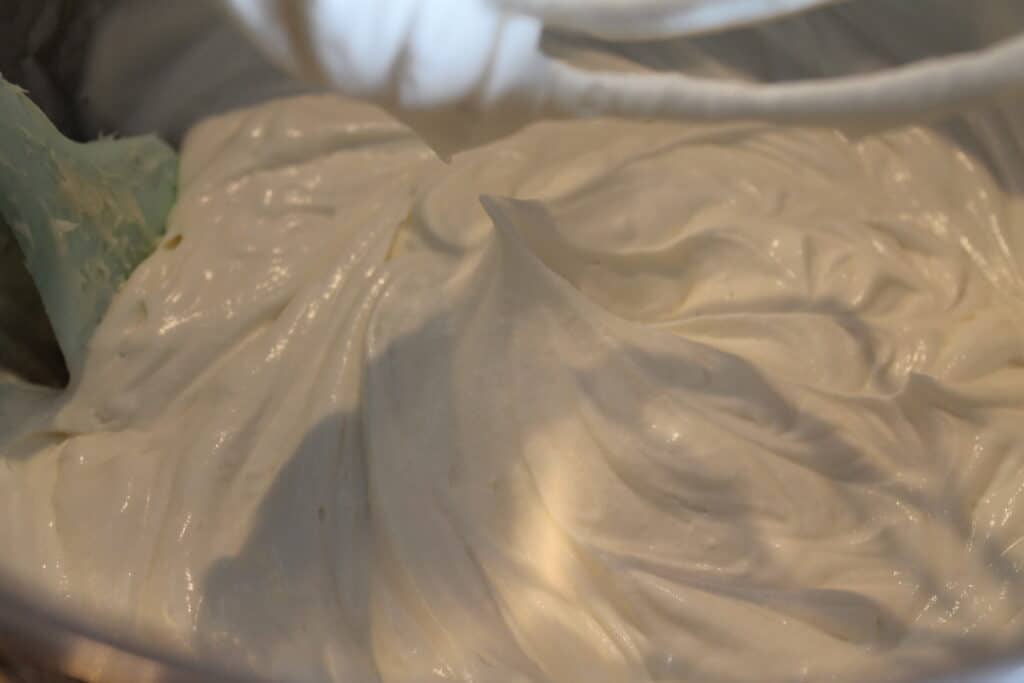 bowl of whipped cream frosting showing how thick it is