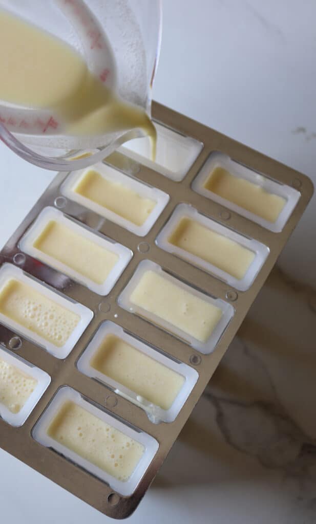 pouring the creamsicle liquid into the popsicle molds