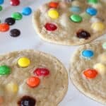 image of m&m cookies with chocolate m&m's spread out beside them