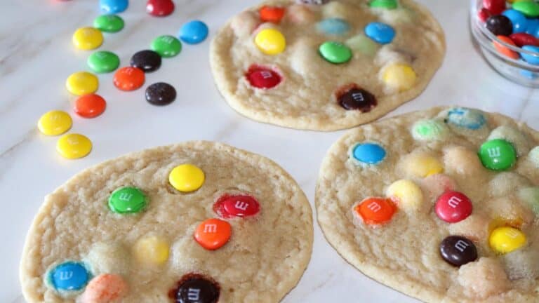 image of m&m cookies with chocolate m&m's spread out beside them