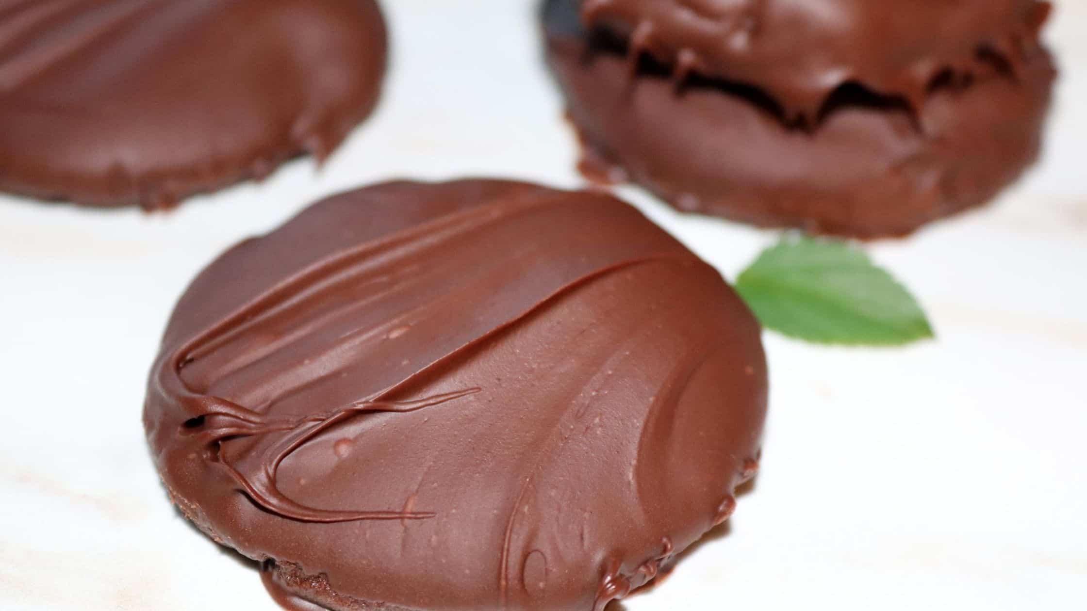 chocolate thin mint cookies on a plate with a mint leaf in the background