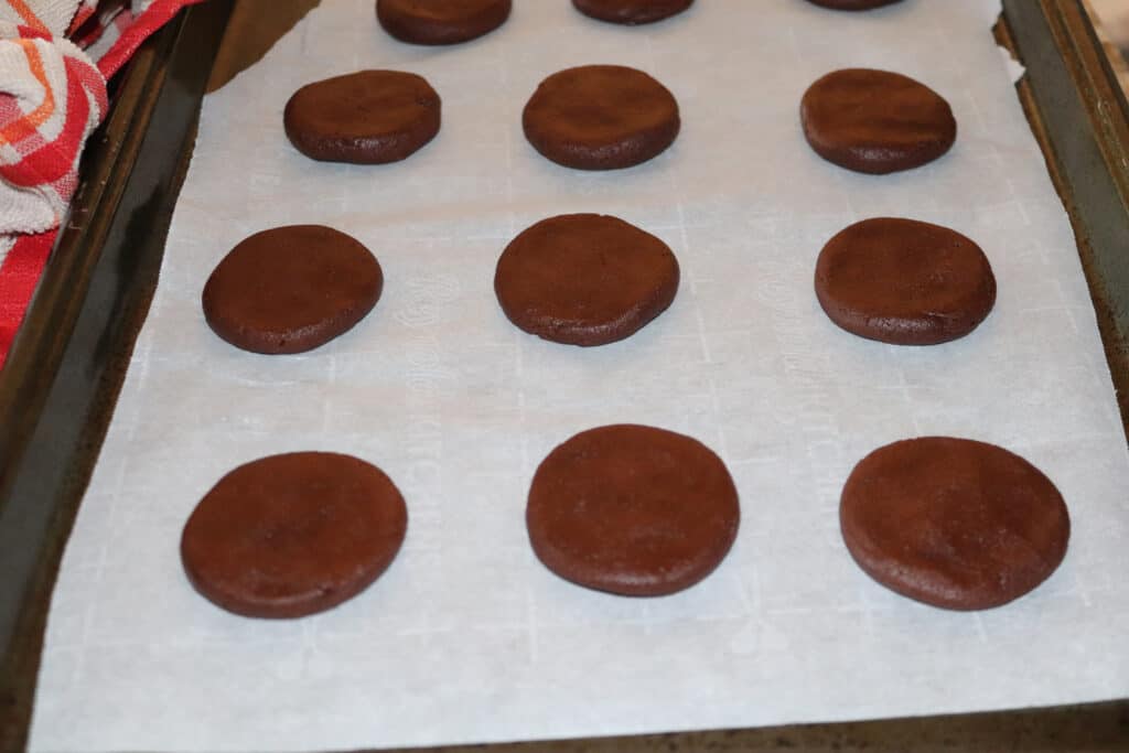 unbaked chocolate thin mint discs on a parchment paper