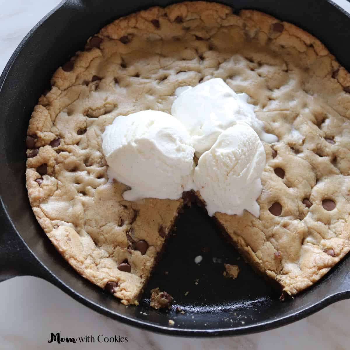 chocolate chip skillet cookie with ice cream on top and a slice missing