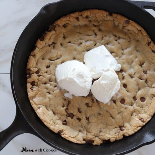 chocolate chip cookie in a cast iron skillet with three scoops of ice cream on top
