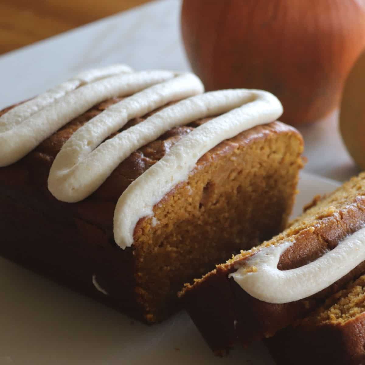 homemade pumpkin bread sliced with brown butter icing added on top